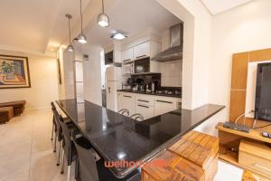 eine große Küche mit einer großen schwarzen Arbeitsplatte in der Unterkunft Apto Praia das Pitangueiras com Piscina aquecida in Guarujá