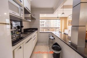 eine kleine Küche mit Spüle und Fenster in der Unterkunft Apto Praia das Pitangueiras com Piscina aquecida in Guarujá + 28 Fotos