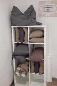 a white book shelf with pillows on it at Pension Dalinghaus in Vörden