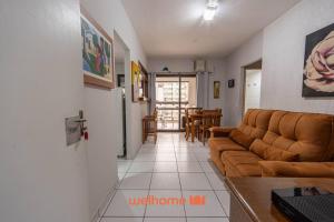 グアルジャにあるApartamento em Guarujá próximo ao Shopping La Plageのソファとテーブルのあるリビングルーム