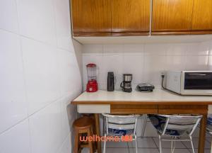 グアルジャにあるApartamento em Guarujá próximo ao Shopping La Plageのキッチン(電子レンジ、椅子付きのカウンター付) +30枚の写真