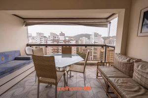 d'un balcon avec une table, des chaises et un canapé. dans l'établissement Apto em Guarujá a passos da Praia das Pitangueiras, à Guarujá