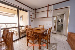 une salle à manger avec une table et des chaises en bois dans l'établissement Apto em Guarujá a passos da Praia das Pitangueiras, à Guarujá 30 autres photos