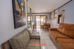 un salon avec un canapé et une table dans l'établissement Apto em Guarujá a passos da Praia das Pitangueiras, à Guarujá