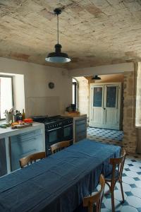 a kitchen with a table with a blue table cloth at Les Toiles du 15 in Montaren-et-Saint-Médiers