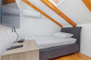 a bedroom with a bed and a desk with a tv at Apartments by the sea Drasnice, Makarska - 23854 in Drašnice