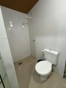 a bathroom with a white toilet in a room at Quarto próximo ao centro in Manaus