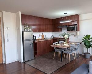 a kitchen with a table and a refrigerator at Santiago de las alturas in Santiago