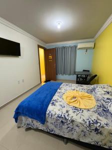 a bedroom with a bed with a yellow towel on it at Quarto próximo ao centro in Manaus