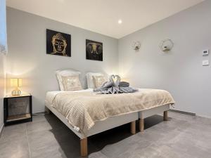 a bedroom with a bed and two pictures on the wall at Appartement Le Cosy Proche Station Ski - Piscine in Saint Avre la Chambre