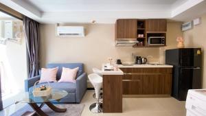 a small apartment with a blue couch and a kitchen at Condo 1BR Naiharn Beach by IBG Property P204 in Phuket Town