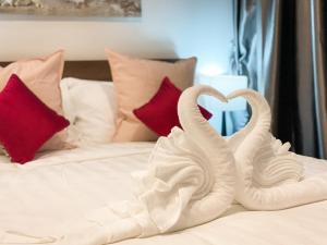 two white swans making a heart on a bed at Condo 1BR Naiharn Beach by IBG Property P204 in Phuket Town +4 photos
