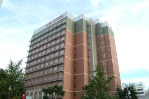 un edificio alto marrón con muchas ventanas en Hotel IL Cuore Namba, en Osaka