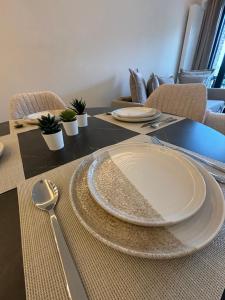 a dining room table with a plate and a spoon at Luxury 1 Bedroom Apartment with Sofa Bed & Balconies Prime Location near ING Arena, Expo 12 & Atomium in Wemmel +9 photos