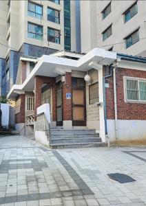 a building with a porch and stairs in front of a building at FLYING Stay 플라잉스테이 in Seoul