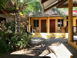 a house with a palm tree in front of it at Gold Star Inn in Siquijor