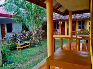 a balcony of a house with a palm tree at Gold Star Inn in Siquijor