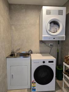 a kitchen with a washing machine and a sink at Paramount Suite on Parkes Pool And City View in Sydney