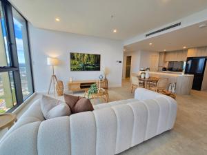 a living room with a white couch and a kitchen at Paramount Suite on Parkes Pool And City View in Sydney