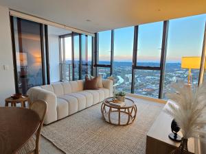 a living room with a white couch and large windows at Paramount Suite on Parkes Pool And City View in Sydney