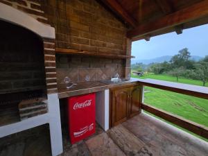 an outdoor kitchen with a cocacola sink and a fireplace at Cabaña el rio Rincon Verde in Tomatlán