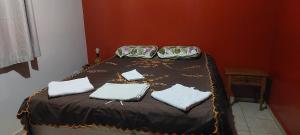 a bed with three pillows on it in a room at Quarto individual em apto aconchegante in Sao Jose do Rio Preto