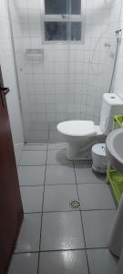 a white bathroom with a toilet and a shower at Quarto individual em apto aconchegante in Sao Jose do Rio Preto