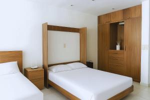 a bedroom with two beds and a wooden headboard at Aria Ocean Confort in Bucerías