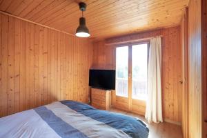 sypialnia z łóżkiem i dużym oknem w obiekcie Panorama Chalet Ovronnaz 180 View 2BA 10 pax w mieście Ovronnaz