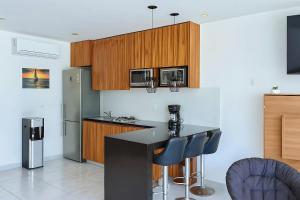 a kitchen with wooden cabinets and a black counter top at Aria Ocean Confort in Bucerías