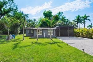 a small house in a yard with a green lawn at 5 Min to Sanibel 10 Min to FM Beach 4BR Oasis in Fort Myers