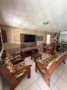 a living room with couches and a flat screen tv at Meu Aconchego in Tamandaré