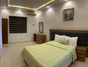 a bedroom with a large bed with a green blanket at Serene BetHadel Apartment in Ijaiye