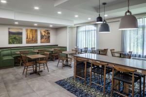 a dining room with tables and chairs and windows at Fairfield Inn & Suites Butler in Butler
