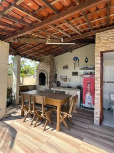 a wooden table and chairs on a patio with a kitchen at Meu Aconchego in Tamandaré