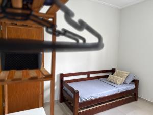 Una pequeña habitación con una cama y un estante. en Conforto a 8min da Canção Nova com Garagem, en Cachoeira Paulista