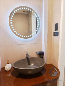 - Baño con lavabo y espejo redondo en Makadal'Eau Boutique Resort, en Siquijor