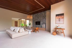 a living room with a white couch and a fireplace at Casa Varandas Morro de São Paulo in Cayru