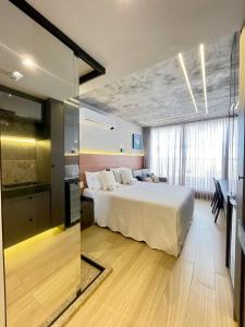 ein Hotelzimmer mit einem Bett und einer Glaswand in der Unterkunft Setai Yacth, Flat para até 03 pessoas a beira mar do Cabo Branco in João Pessoa + 12 Fotos