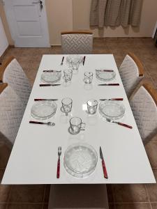 a white table with glasses and plates on it at Lihuel AG in Alta Gracia