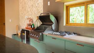 a kitchen with a stove and a window at Casa Varandas Morro de São Paulo in Cayru