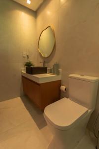 a bathroom with a white toilet and a mirror at Casa Varandas Morro de São Paulo in Cayru +4 photos
