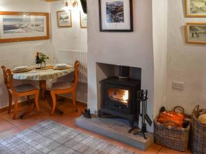 een eetkamer met een tafel en een open haard bij Swinside Cottage in Ennerdale Bridge