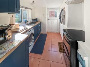 een keuken met wasmachine en droger bij Swinside Cottage in Ennerdale Bridge
