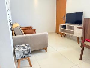 a living room with a couch and a tv at Apartamento em frente ao novo shopping in Ribeirão Preto