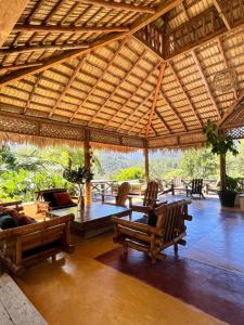 un grand pavillon en bois avec des chaises et une table dans l'établissement Diferencia eco retreat, à San José de Las Matas