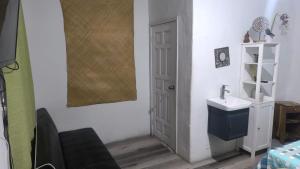 a bathroom with a sink and a white door at La casa de don Matilde in San Pedro Sula