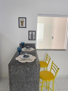 a kitchen with a counter with chairs and a table at Apartamento dois quartos acolhedor prox Hospital Regional e Rodoviária in Santo Antônio de Jesus