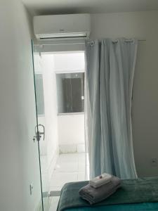 a bedroom with a bed and a window with a curtain at Apartamento dois quartos acolhedor prox Hospital Regional e Rodoviária in Santo Antônio de Jesus