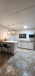 a large white kitchen with a counter and a table at Departamento PL in Paso de los Libres